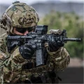 Kolimator holograficzny Vortex Razor UH-1 Gen II zamontowany na broni, strzelec składający się do strzału