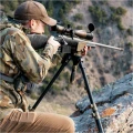 Trójnóg Primos Trigger Stick Apex - zdjęcie w górach, myśliwy w kamuflażu celujący z karabinu opartego na trójnogu