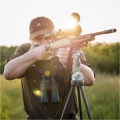 Trójnóg Primos Trigger Stick Gen III™ 24-62'' - zdjęcie w plenerze, myśliwy celujący z karabinu opartego na trójnogu, zachód słońca