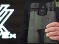 Lornetka Vortex Kaibab HD 18x56 w ręku, z logo Vortex w tle