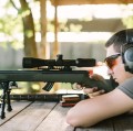 Luneta celownicza Primary Arms Classic 3-9x44 mm SFP Duplex, 30 mm - myśliwy celujący z broni z nowoczesną lunete celownicza na  tle altany