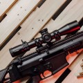 Luneta celownicza Primary Arms GLx 3-18x44 mm FFP iR ACSS Apollo 6.5CR/.224V - broni z nowoczesną luneta celownicza leżąca na drewnianym stole