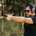 Kolimator Vortex Defender-CCW Solar 3 MOA na broni w dłoniach celującej kobiety