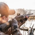 Kolimator do strzelby Vortex Viper Shotgun Enclosed Micro Green Dot Multi-Reticle na strzelbie, celujący mężczyzna