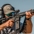 Strzelec celujący z karabinka wyposażonego w kolimator Vortex Crossfire II Solar Red Dot podczas treningu strzeleckiego