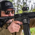Kolimator Vortex Crossfire II Solar Green Dot widok strzelca z bronią i zamontowanym kolimatorem