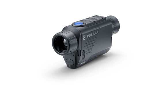 Pulsar Axion Compact XG30 termowizor w ujęciu ukośnym na czarnym tle, widoczny niebieski przycisk i port USB na obudowie.